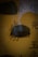 A piece of dark, curved artifact is displayed against a yellow background with large Chinese characters. The artifact appears to have carvings or engravings on its surface. A shadow, possibly of a person's silhouette, can be seen overlapping the artifact.