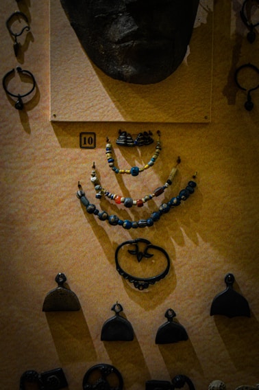 Close-up of a vibrant African mask resting beside a cluster of colorful crystals and a handmade necklace.