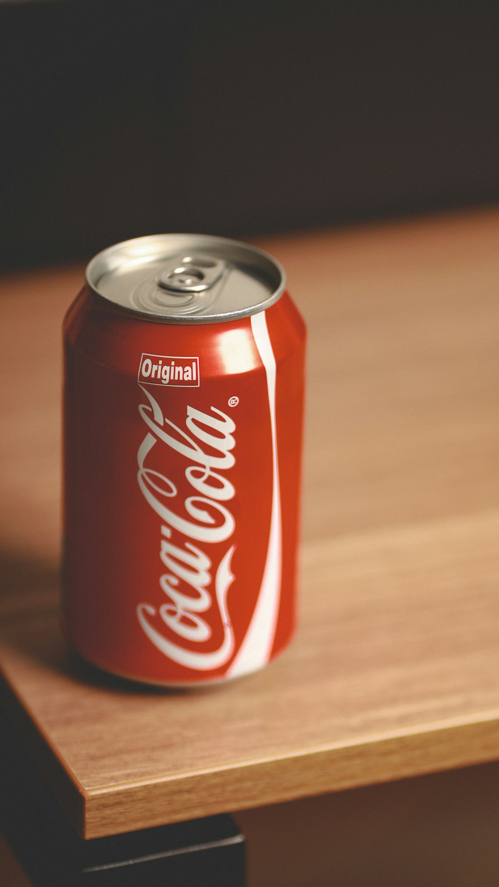 a can of coca - cola sitting on top of a wooden table