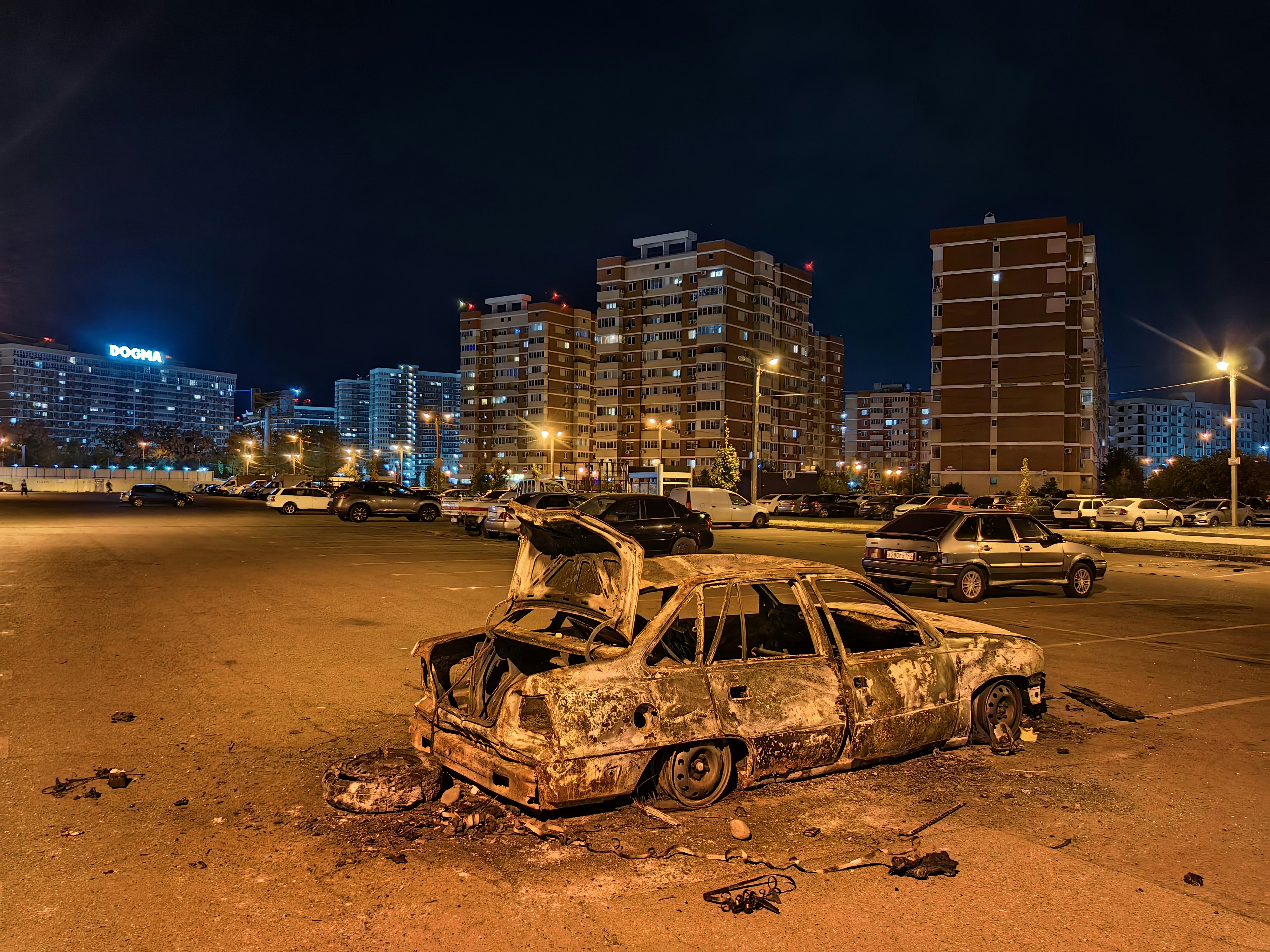 a burnt out car sitting in a parking lot