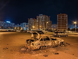 a burnt out car sitting in a parking lot