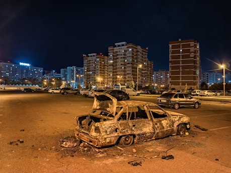 a burnt out car sitting in a parking lot