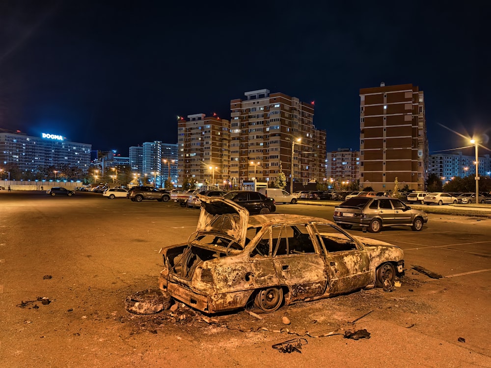 a burnt out car sitting in a parking lot