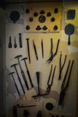 A collection of memorabilia including old badges, tools, and uniforms from the electrical sector.