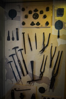 Close-up of vintage tools and household objects on display.