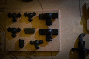 A collection of BDSM tools artfully arranged on a jet-black surface, hinting at disciplined indulgence.