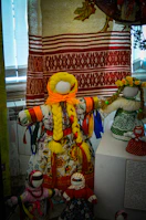 A colorful array of Kondapalli dolls arranged on a rustic wooden shelf.