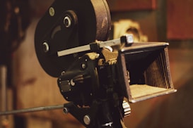 A vintage film camera with intricate mechanical details and a lens hood, showcasing classic filmmaking equipment.