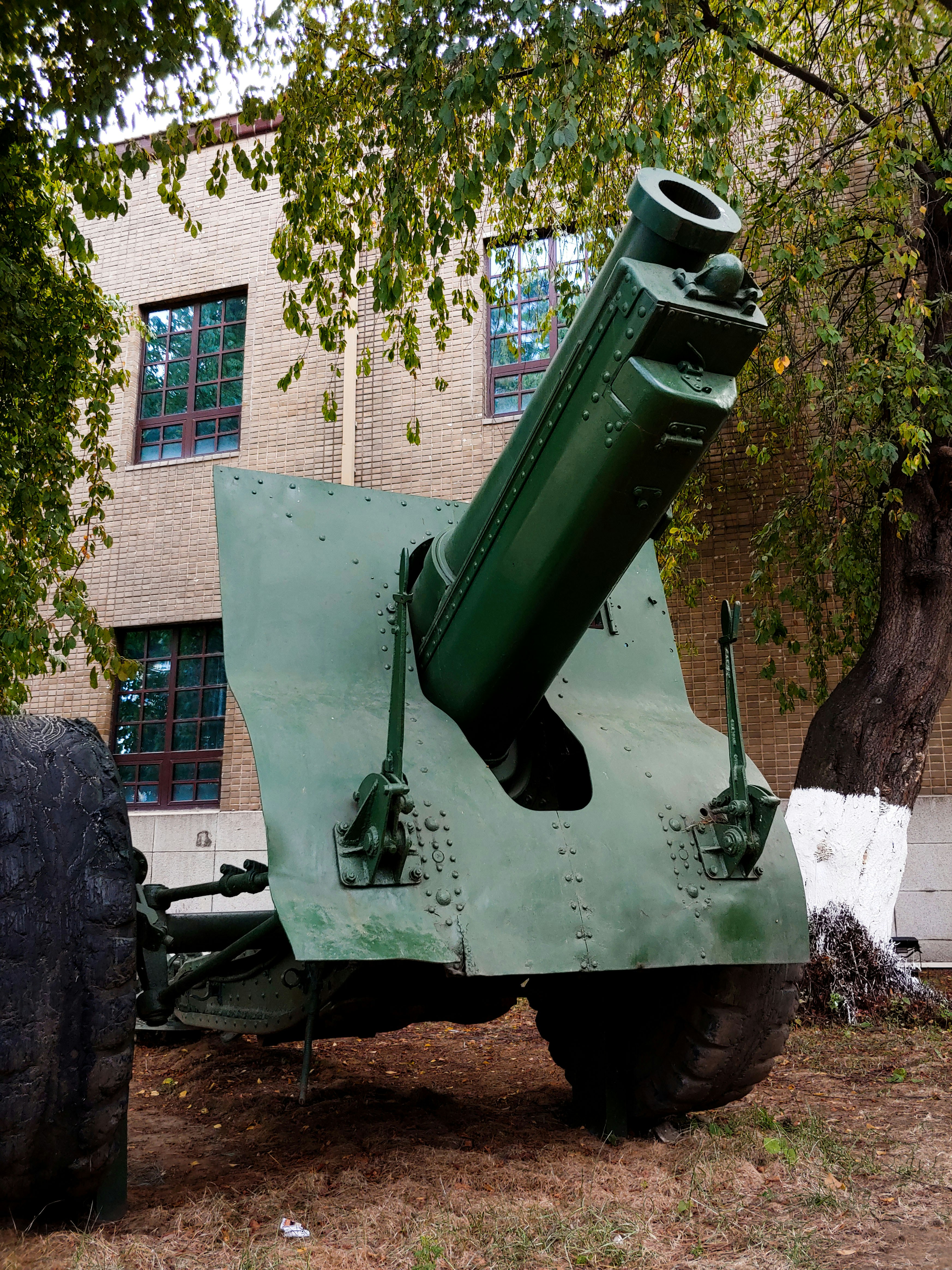 a large green military vehicle parked in front of a building