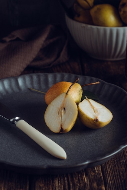 a plate with a knife and some apples on it