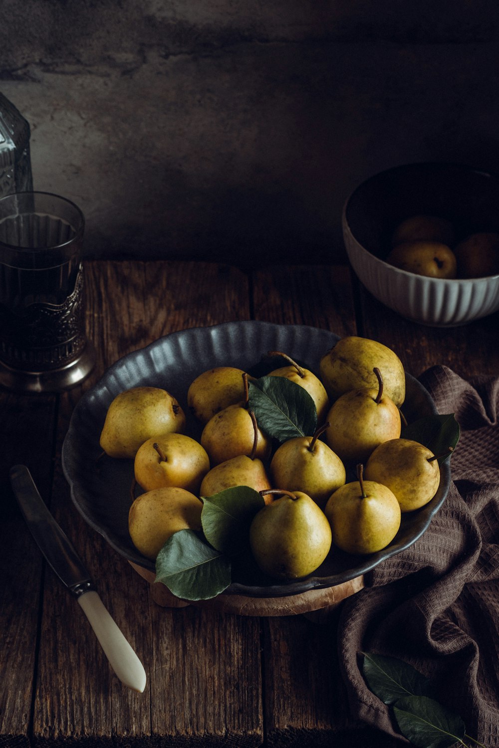 a bowl of pears on a wooden table