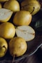 a plate of pears and a leaf on a table