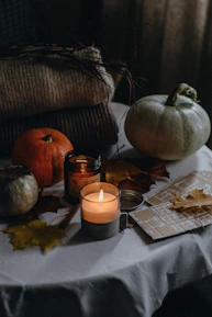 A pair of matching couple's scarves laid out on a rustic wooden table with autumn leaves.