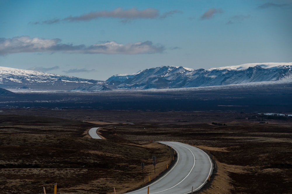 a winding road with a mountain in the background