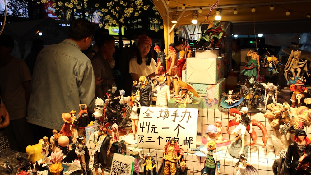 a group of people standing around a display of dolls