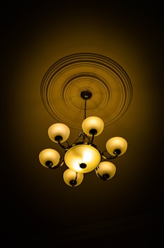 Warmly lit traditional chandelier blending into sleek modern ceiling lights.