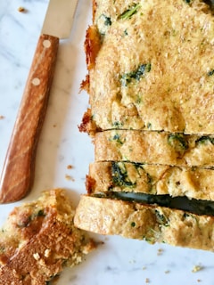 An overhead shot of a savory inclusion loaf sliced open to reveal olives and herbs inside.