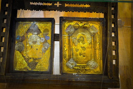 Close-up of a finely carved wooden Orthodox icon with soft golden light highlighting the details.