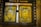 Two ornate golden religious icons are set within a wooden frame. The icons are richly decorated with detailed engravings, featuring religious figures surrounded by intricate patterns and floral motifs. The woodwork surrounding the icons is dark and rustic, contrasting with the vivid gold.
