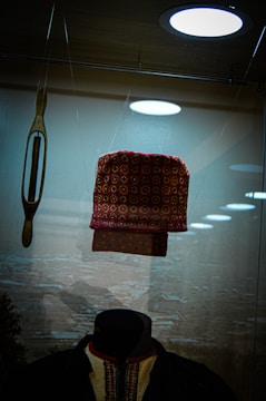 A colorful fanhat displayed on a wooden stand in the studio.