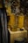 A display of intricately designed wooden containers and a fabric drape. The containers have detailed carvings and patterns, showcasing expert craftsmanship. The drape features a decorative design with blue and brown tones. The background has a textured appearance.