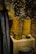 A display of intricately designed wooden containers and a fabric drape. The containers have detailed carvings and patterns, showcasing expert craftsmanship. The drape features a decorative design with blue and brown tones. The background has a textured appearance.