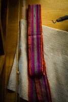Close-up of a handcrafted folkloric textile used as a backdrop in a cultural interview setting.