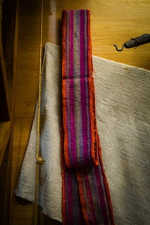 Close-up of a handcrafted folkloric textile used as a backdrop in a cultural interview setting.