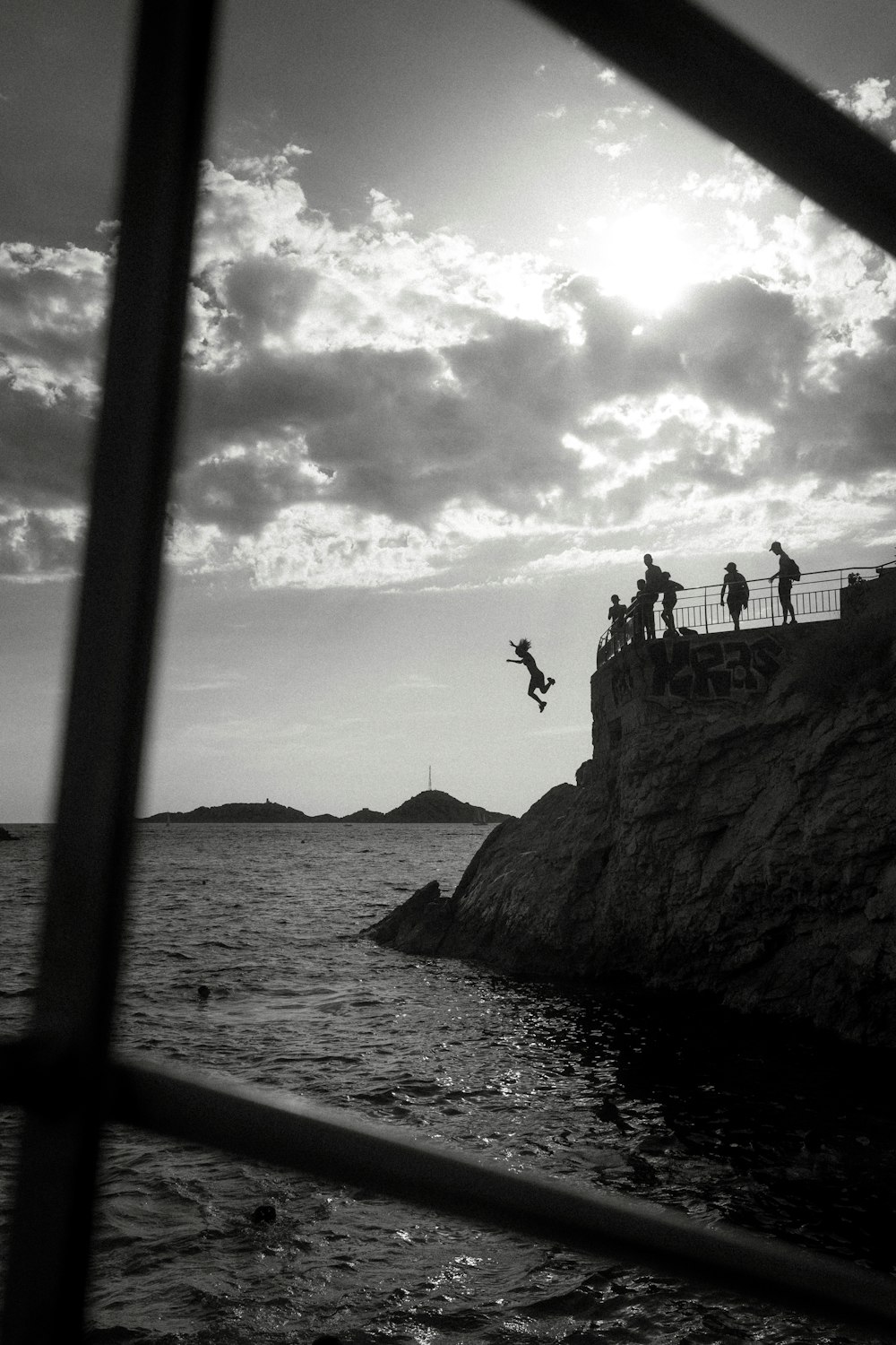 a person jumping off a cliff into the water