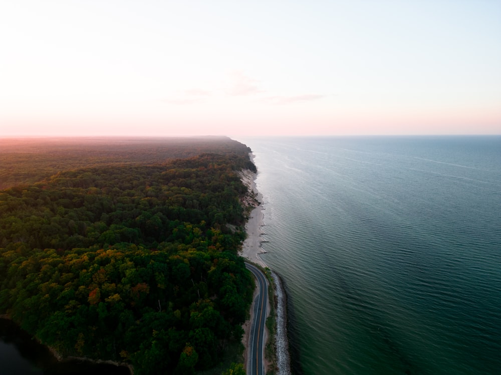 an aerial view of a road next to a body of water