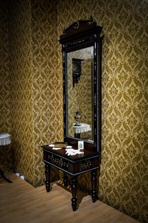 Delicate vintage dresser topped with old-fashioned perfume bottles and a vintage mirror