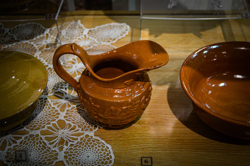 A close-up of traditional Romanian pottery displayed on a rustic wooden table.