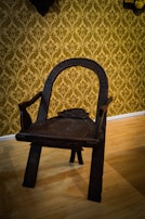 An intricately carved wooden chair with a worn leather seat.