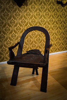 A beautifully crafted wooden chair with intricate detailing in a cozy living room.