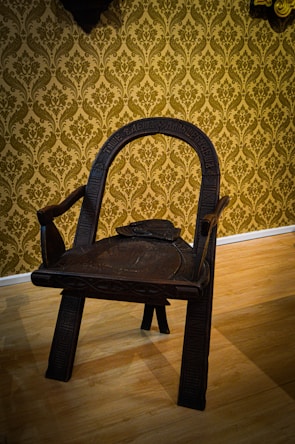 Close-up of a handcrafted chair with intricate Chinese wood carving details.