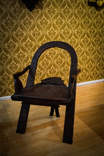 A custom teak wood chair showcasing intricate hand-carved details on the backrest