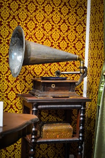 A classic gramophone with a large brass horn sitting next to vinyl records.