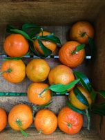 A rustic wooden crate filled with ripe oranges and lemons.