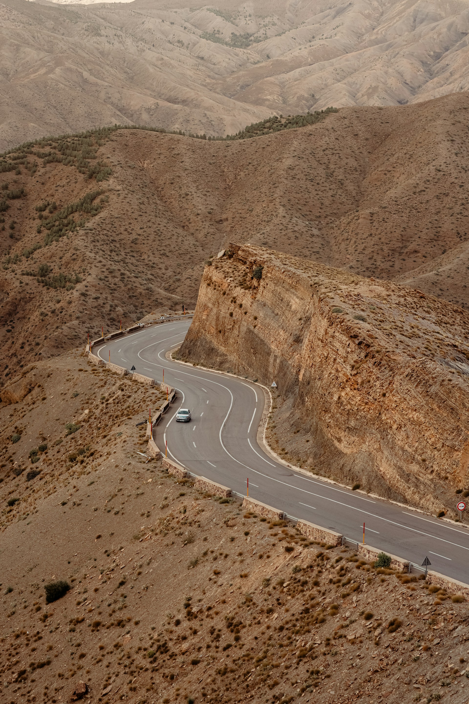 a car driving down a winding road in the mountains