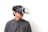 A person wearing a virtual reality headset, gazing off to the side, dressed in a black and white checkered shirt, against a plain white background.