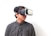 A person wearing a virtual reality headset, gazing off to the side, dressed in a black and white checkered shirt, against a plain white background.