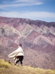 a person walking up a hill with a blanket over their head