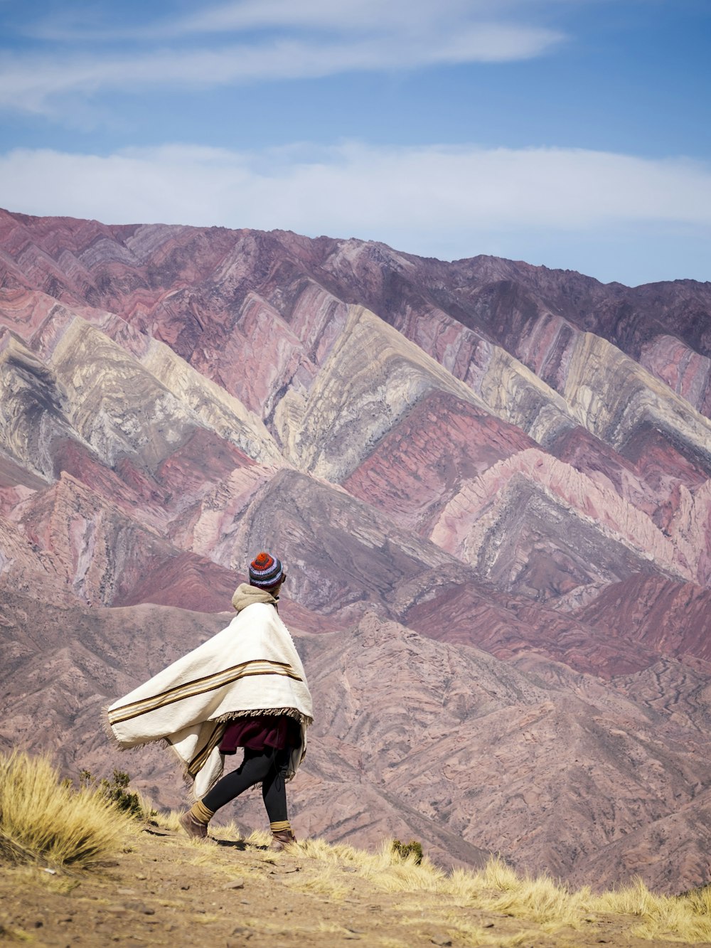 a person walking up a hill with a blanket over their head