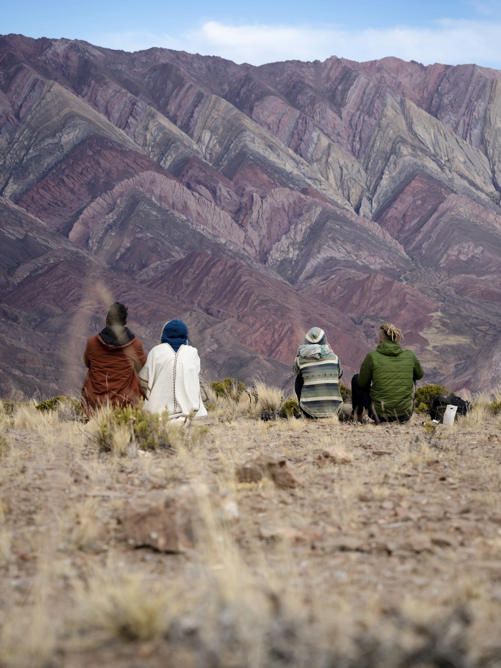 a group of people sitting on top of a hill