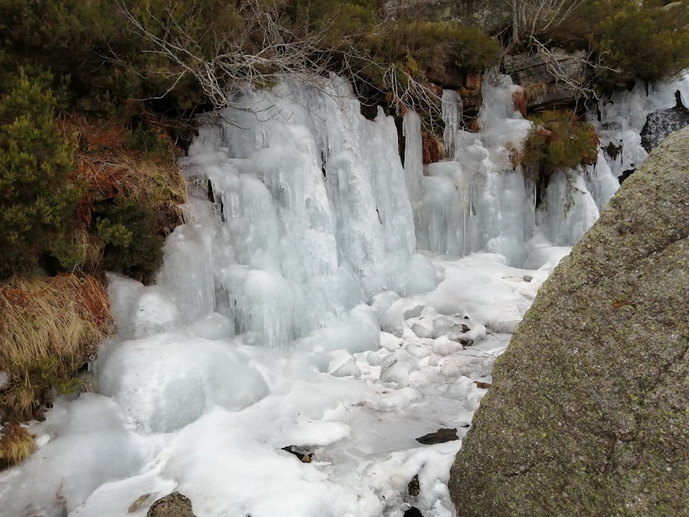 um homem ao lado de uma cachoeira coberta de gelo