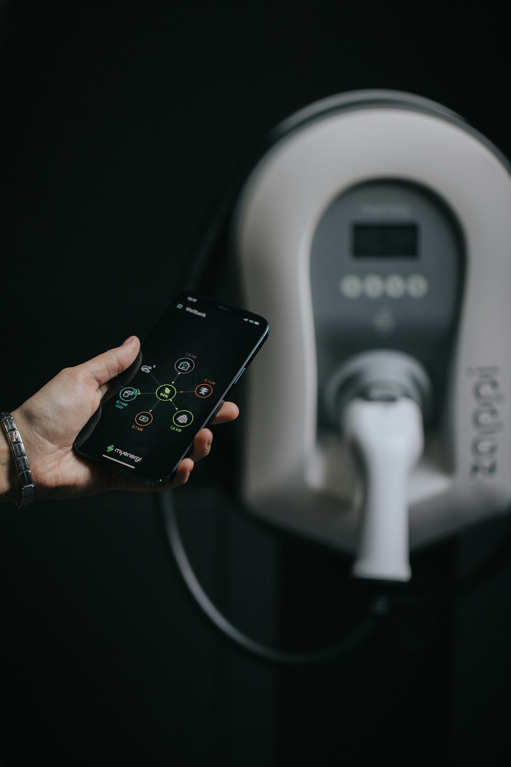 a person holding a cell phone in front of a machine