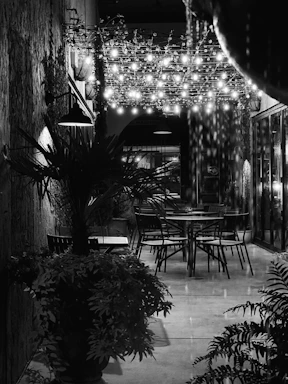 A cozy outdoor seating area with string lights glowing warmly at dusk.
