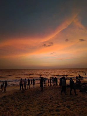 A vibrant beach scene at sunset with people enjoying Sol de Janeiro products.