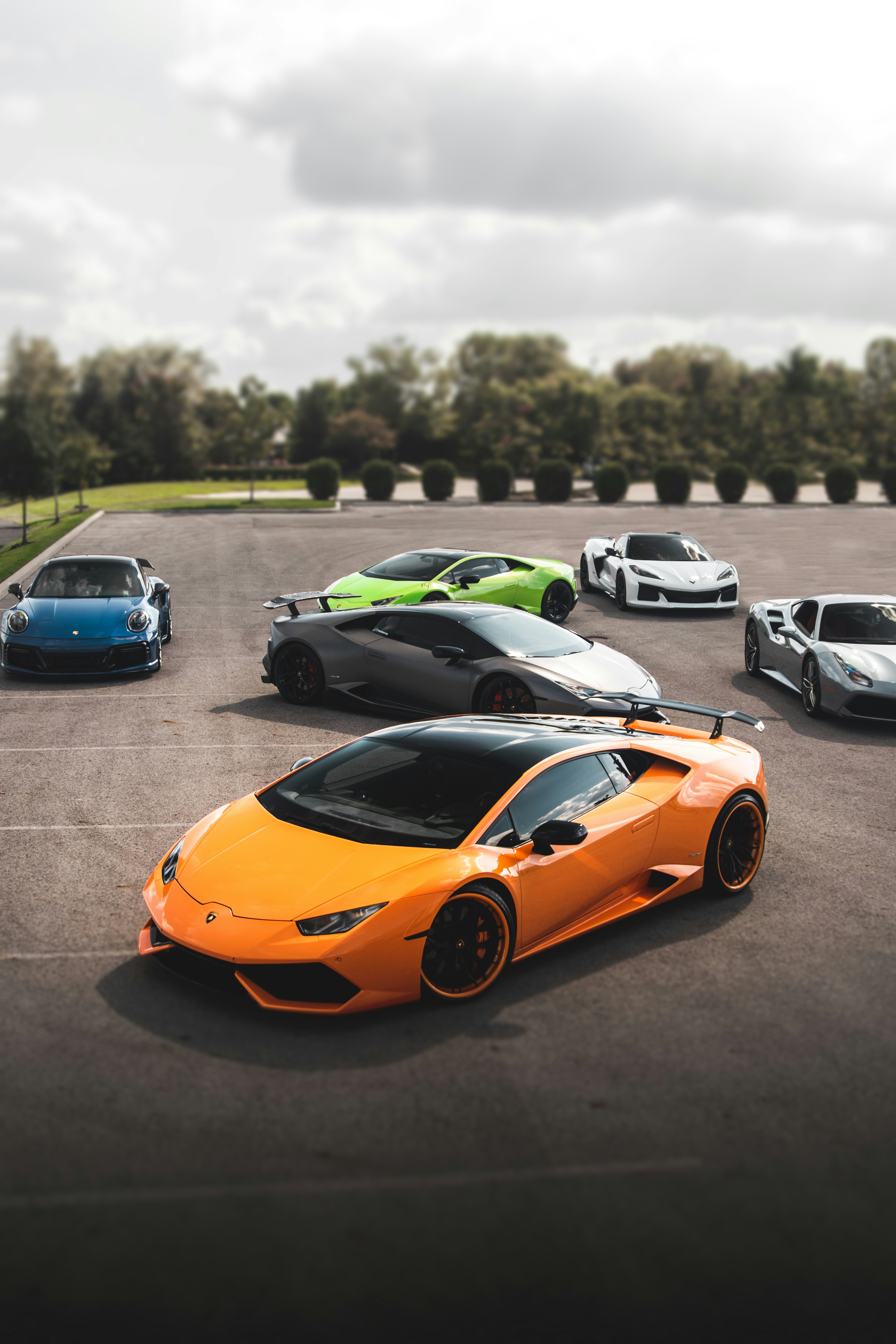A collection of luxury sports cars in a parking lot, representing the GearShift fleet.