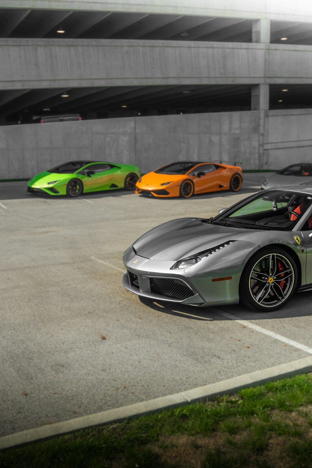 a row of sports cars parked in a parking lot